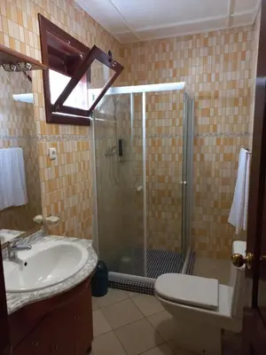 a bathroom with a shower and a toilet and a sink at Hotel Savana in São Filipe