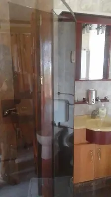 a bathroom with a sink and a glass shower at Residencial Cabo Verde Palace in Santa Maria