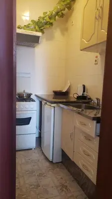 a small kitchen with a sink and a stove at Residencial Cabo Verde Palace in Santa Maria
