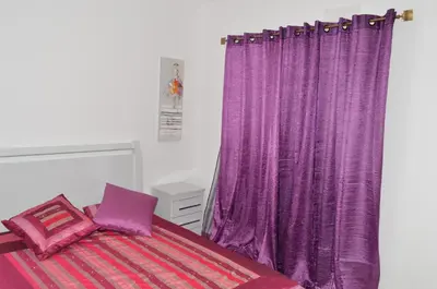 a purple curtain in a bedroom with a bed at House Gonçalves in Praia