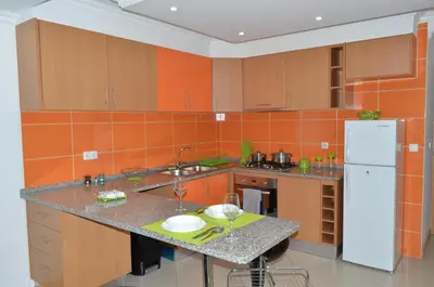 a kitchen with an orange tiled wall at Apartamento Augusto in Praia