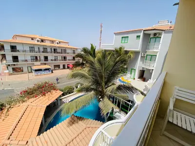a view from the balcony of a hotel with a palm tree at ApartHotel NhaTerra in Santa Maria