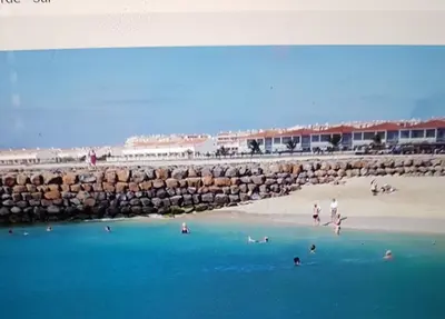 a group of people in the water at a beach at Surf Beach Vila Verde apartments in Santa Maria