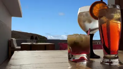 two drinks on a wooden table with an orange slice at Mix 2 in Mindelo