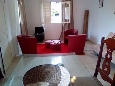 a living room with red chairs and a table at Casa Mendes in Tarrafal