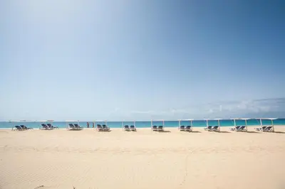 a group of chairs sitting on a beach at Hotel Dunas de Sal in Santa Maria