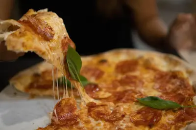 a slice of pizza with cheese and basil on it at Sobrado Boutique Hotel in Santa Maria