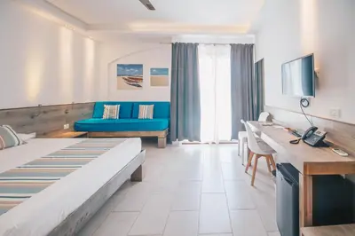 a hotel room with a bed and a blue couch at Sobrado Boutique Hotel in Santa Maria