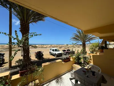a balcony with a view of a desert with a car parked at Vista Do Mar Studio Praia Cabral in Sal Rei