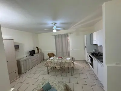 a living room with a table and a kitchen at Vista Do Mar Studio Praia Cabral in Sal Rei