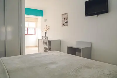 a bedroom with a bed and a desk and a television at Hotel LIVVO Don Paco in Mindelo
