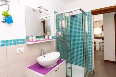 a bathroom with a sink and a glass shower at Apartamento Las Rochas in Mindelo