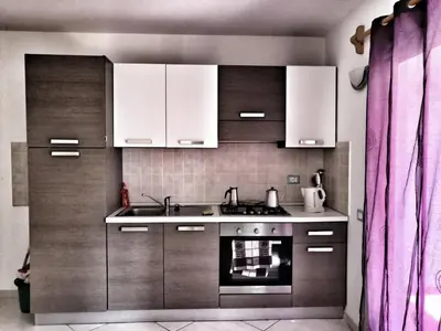 a kitchen with white cabinets and a sink and an oven at Sal Service beachside angulo in Santa Maria
