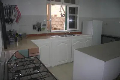 a kitchen with a sink and a white refrigerator at Surf House Hostel in Santa Maria