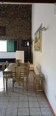 a dining room with a wooden table and chairs at Surf House Hostel in Santa Maria