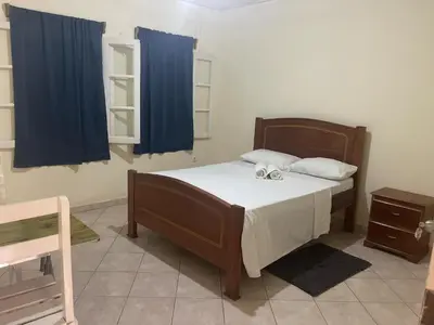 a bedroom with a bed with a blue curtain at Pensão Domingas in São Filipe