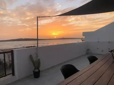 a table and chairs on a balcony with a sunset at Casa Tud Dret - By Bobbywashere in Sal Rei