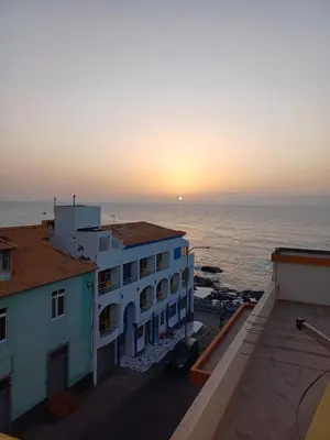 a view of the sunset from the balcony of a building at Casa Amarela in Ponta do Sol