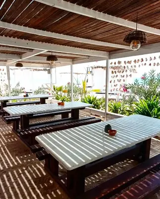 a row of picnic tables on a patio at SGC Boa Vista Apartments in Sal Rei