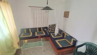 a living room with two beds and a table at Pensão Alcinda Bettencourt 50 meters to the Beachfront in Santa Maria