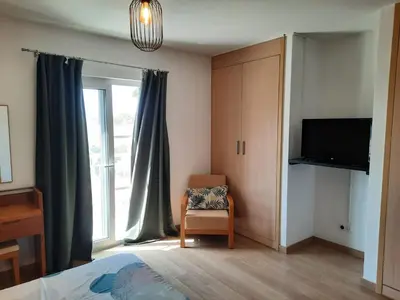 a bedroom with a bed and a tv and a window at Guesthouse Le Châtelain in Santa Maria
