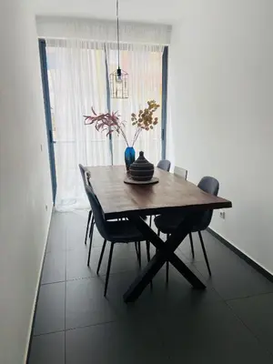 a dining room table with chairs and a vase on it at Morabezahome in Mindelo