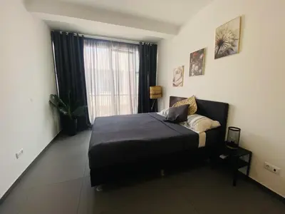 a bedroom with a bed and a large window at Morabezahome in Mindelo