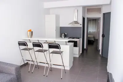 a kitchen with a white counter and stools at Morabezahome in Mindelo
