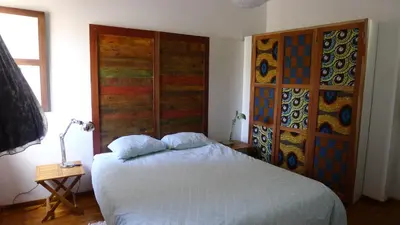 a bedroom with a bed and a wall with stained glass at Casa Verde in Mindelo