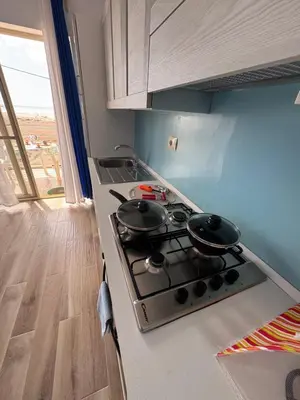a kitchen with a stove with two pots on it at KA ANGELA, WI-FI FREE Praia Cabral, Sal Rei in Sal Rei