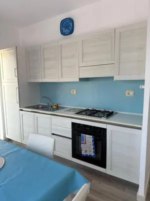 a kitchen with white cabinets and a clock on the wall at KA ANGELA, WI-FI FREE Praia Cabral, Sal Rei in Sal Rei