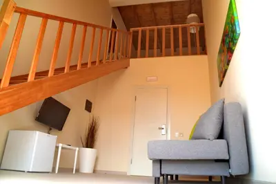 a living room with a chair and a staircase at Ouril Hotel Julia in Santa Maria