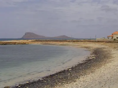 a beach with a house and mountains in the distance at Solmar apartment in Beirona