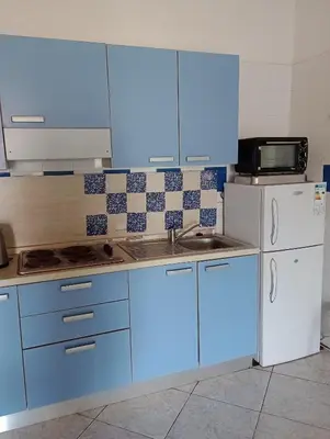 a kitchen with blue cabinets and a white refrigerator at Casa Azul Apt Two Rua da Morna up from Mercado Municipal 4111 in Santa Maria