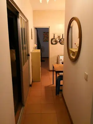 a hallway with a mirror and a table and a refrigerator at Casa Tabanka Apartment in Tarrafal