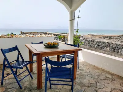 a table with two chairs and a bowl of fruit on it at Casa Branca in Porto Novo