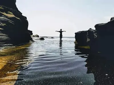 a person standing in the water with their arms outstretched at bed & breakfast Regina in Tarrafal