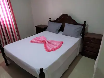 a bedroom with a bed with a pink robe on it at Casa Cabral : Big Apartment next to the beach in Tarrafal