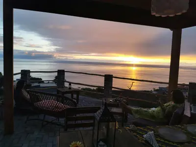 a group of people sitting in chairs watching the sunset at Kaza Ladera in Seladinha