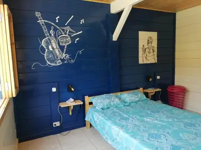 a bedroom with a blue wall with a bed at Casa Madeira in Porto Novo