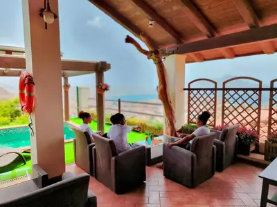 a group of people sitting around a table on a patio at Hotel Belvedere Mindelo, Cabo Verde in Mindelo