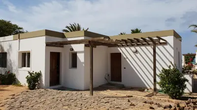 a small white house with a pergola at Beachhaus Praia de Chaves in Cabeçadas
