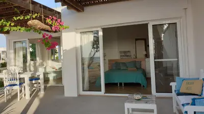 a patio with sliding glass doors and a table and chairs at Beachhaus Praia de Chaves in Cabeçadas