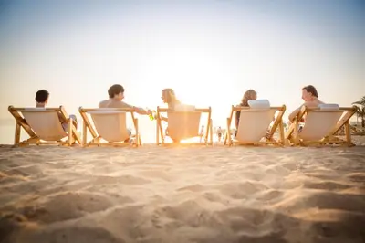 a group of people sitting in chairs on the beach at ROBINSON Cabo Verde - Adults only in Santa Maria