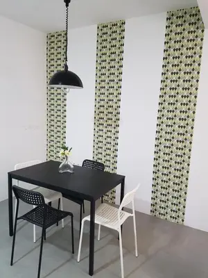 a dining room with a black table and chairs at Casa Io - Djeu in Mindelo