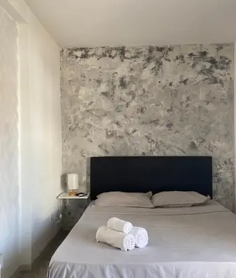 a bedroom with a bed with two towels on it at Cantinho C - Alojamento Complementar in Praia