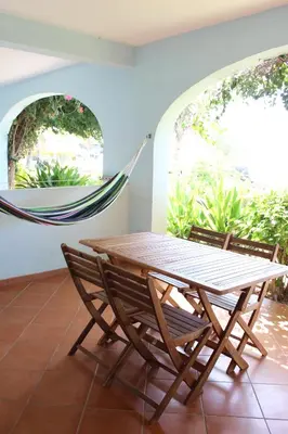 a hammock and a table and chairs in a room at Oceanfront Apt 4 Porto Antigo II in Santa Maria