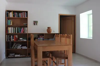 a dining room table with chairs and a book shelf at Casa Pé di Polon holiday home in Picos
