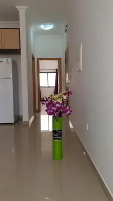 a green vase with purple flowers in a hallway at Appartement de Revé in Praia