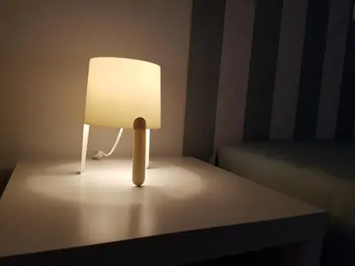 a lamp sitting on a table next to a bed at Casa Io - Goraz in Mindelo